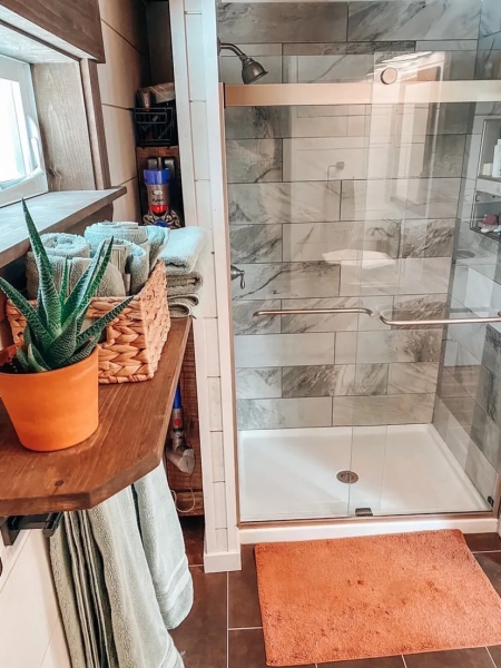 Полноразмерная душевая спрятана за стеклянной дверью.