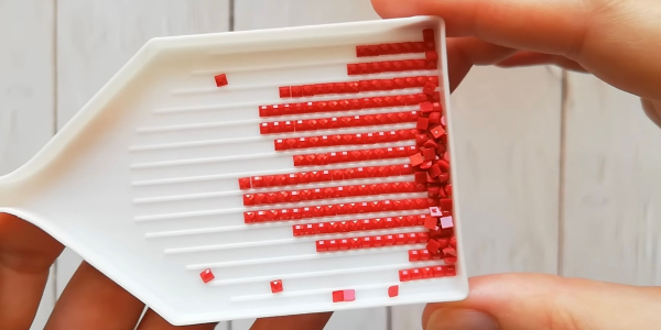 Стрази потрібного кольору помістіть у спеціальний лоток Как собирать алмазную мозаику: нужно высыпать стразы в специальный лоток